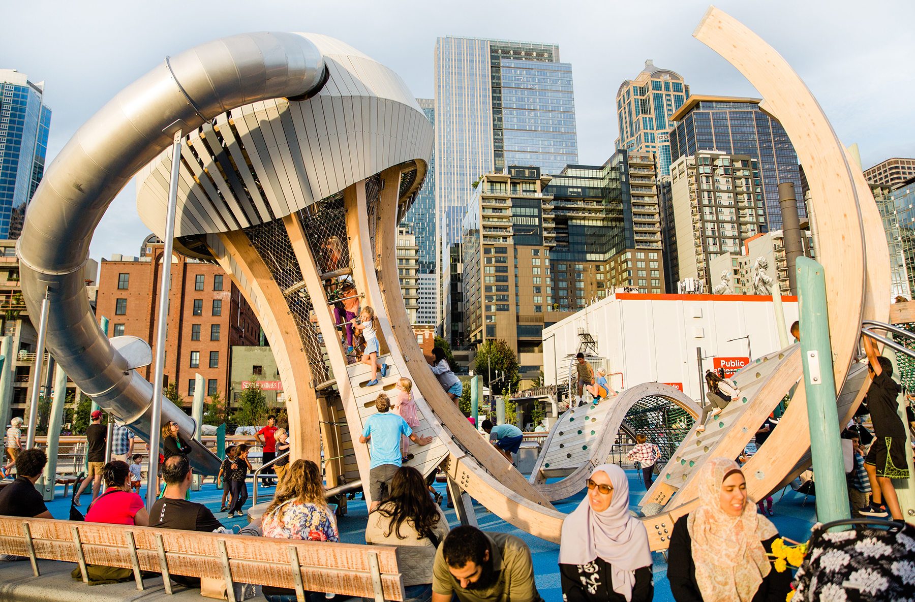 children play on a playground featuring a giant jellyfish-shaped apparatus