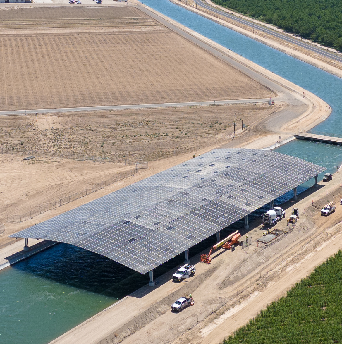 aerial image of solar panels over a wide canal
