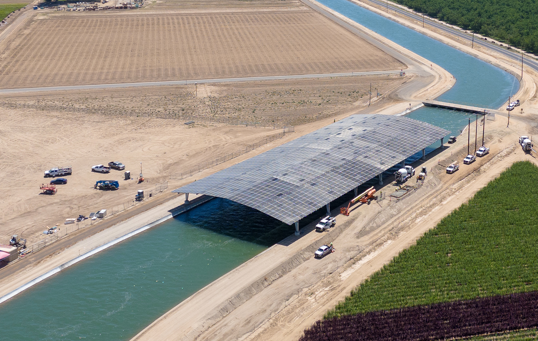 aerial image of solar panels over a canal