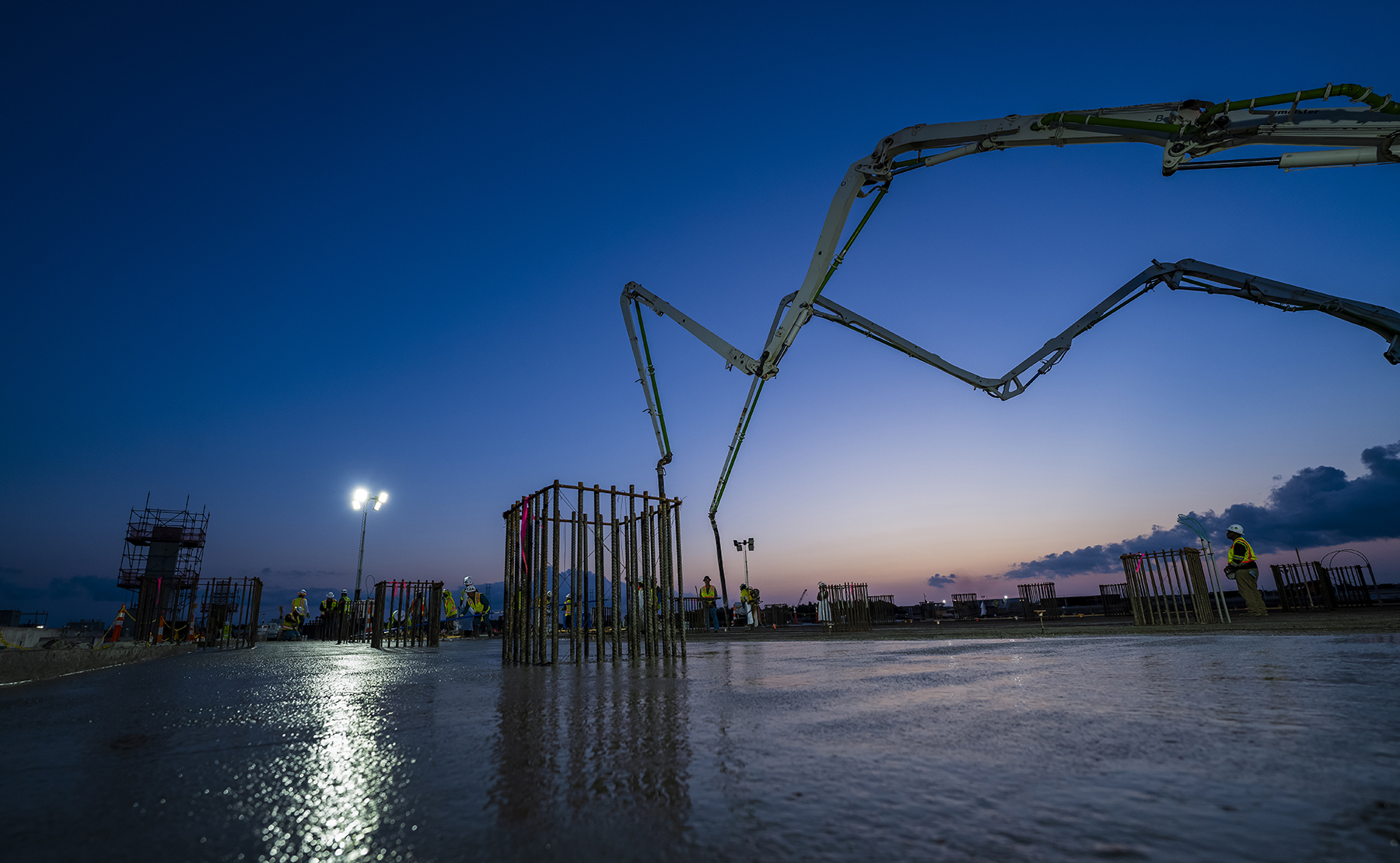 heavy construction equipment at work under a darkened sky