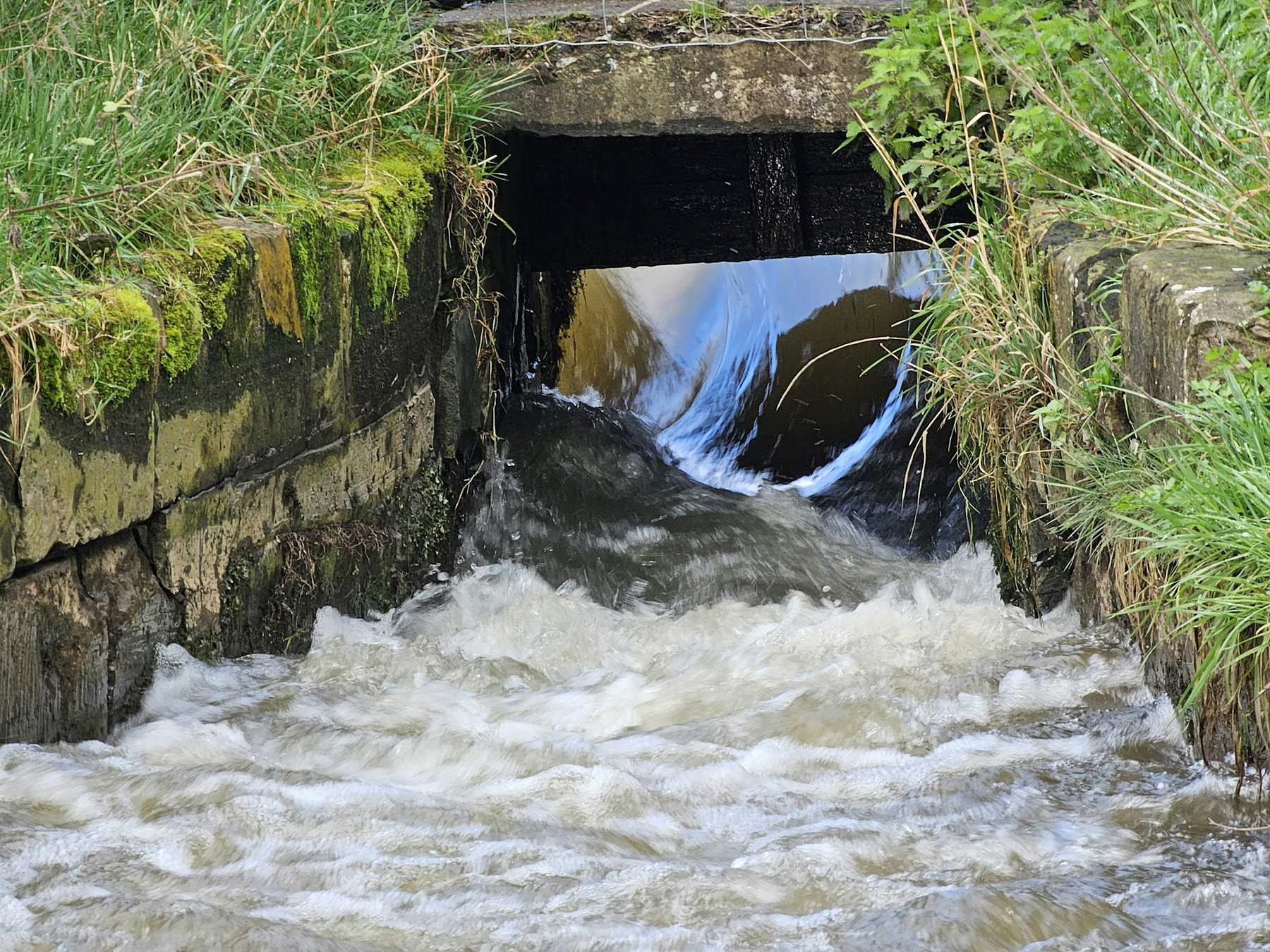 a small stream runs through a stone tunnel
