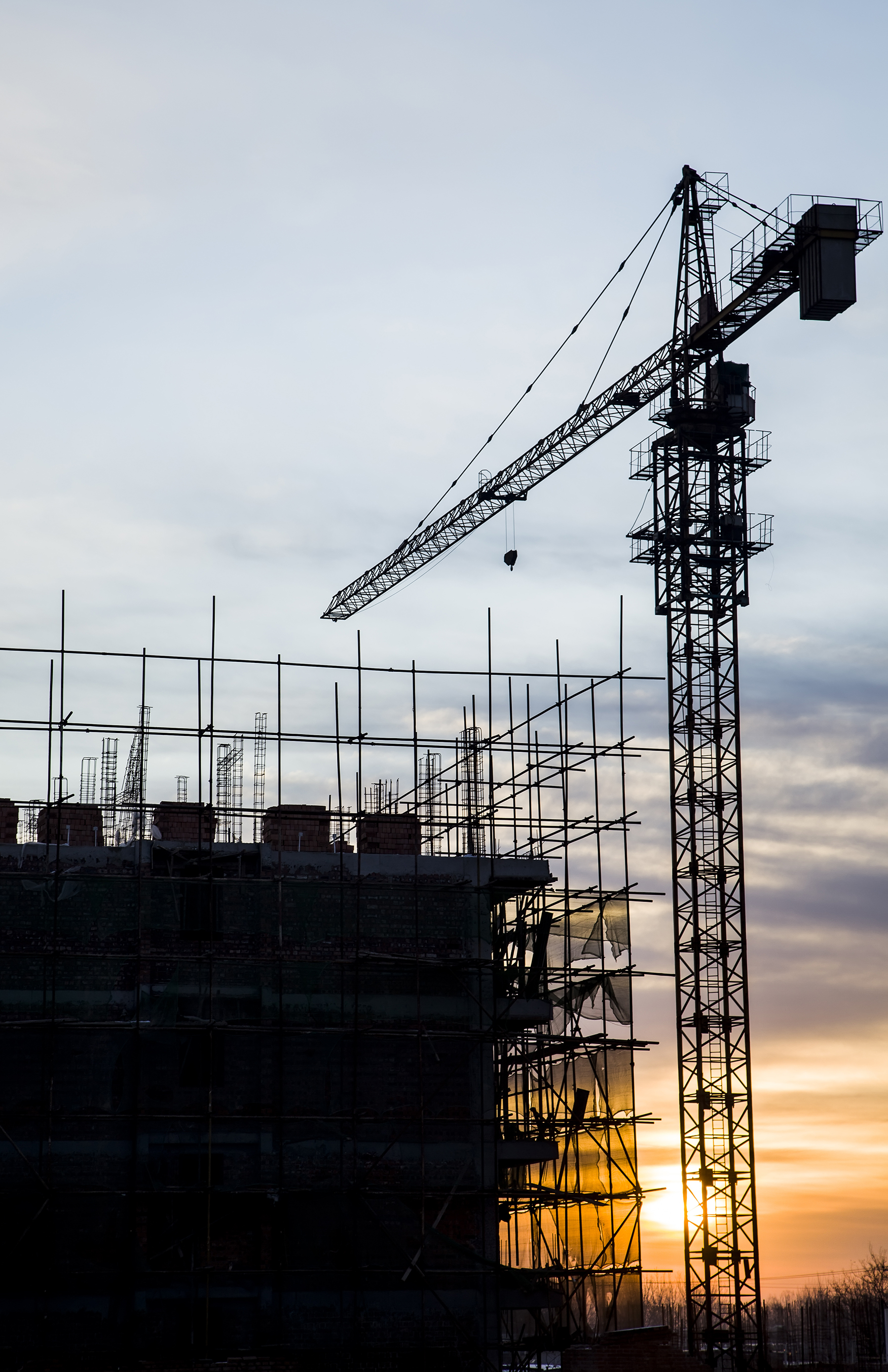 a crane operates near an under-construction structure