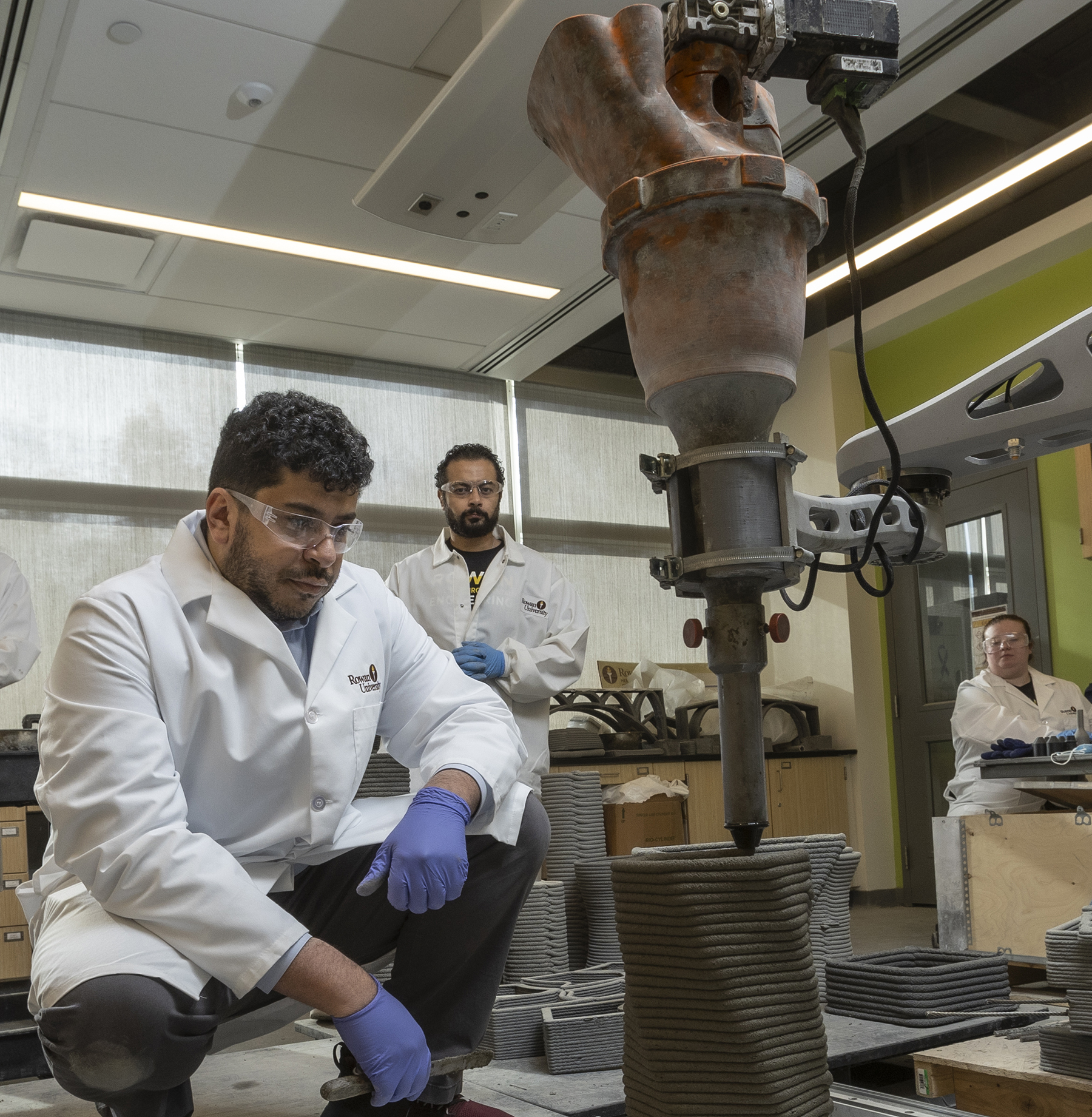 a team in a laboratory setting observes 3D printing