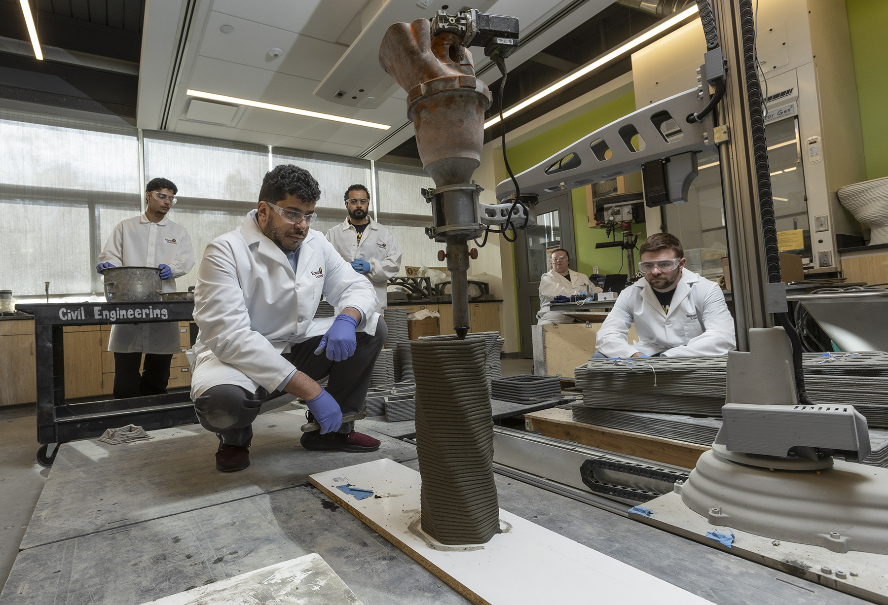 a team in a laboratory setting observes 3D printing