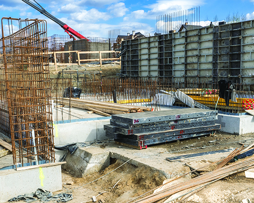 Construction site with foundation work underway in an urban area
