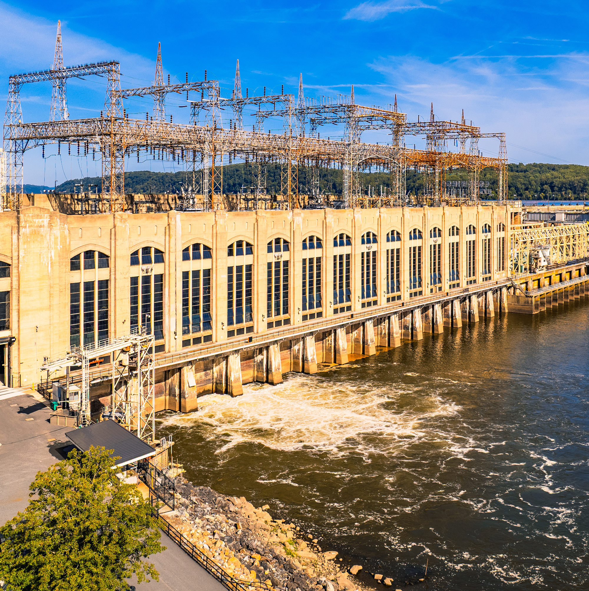 a hydropower dam building beside river with spillway and power equipment