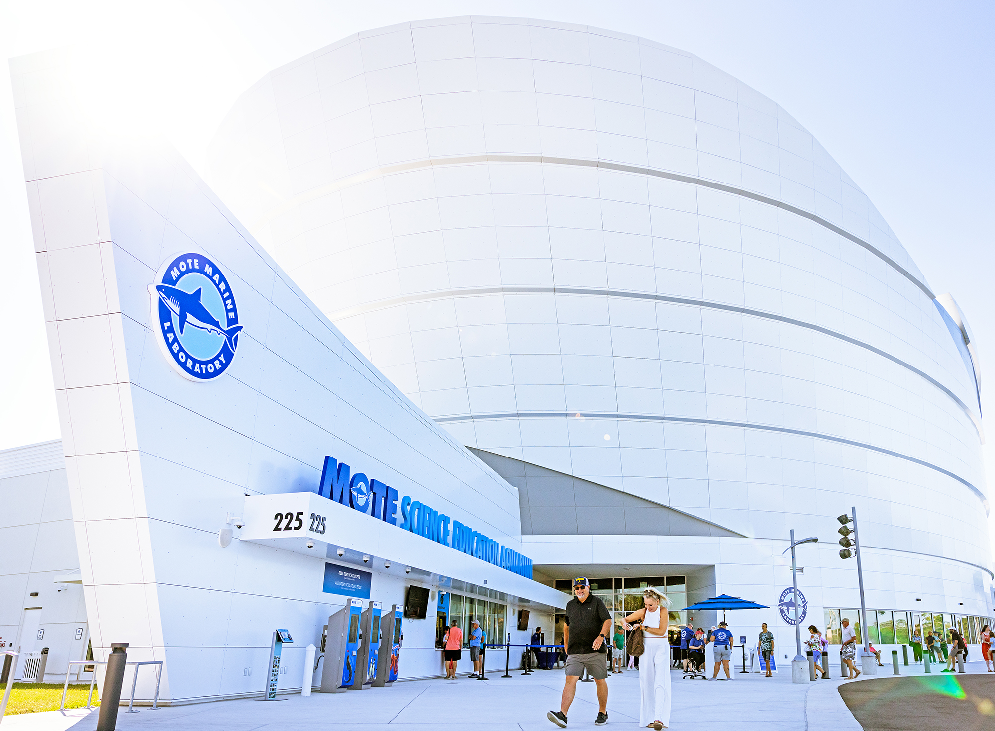 Exterior of Mote Science Education Aquarium with curved white building and visitors outside