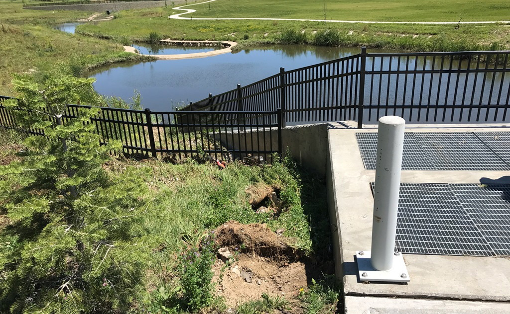 Naturalized stream channel and stormwater basin with erosion near drainage structure