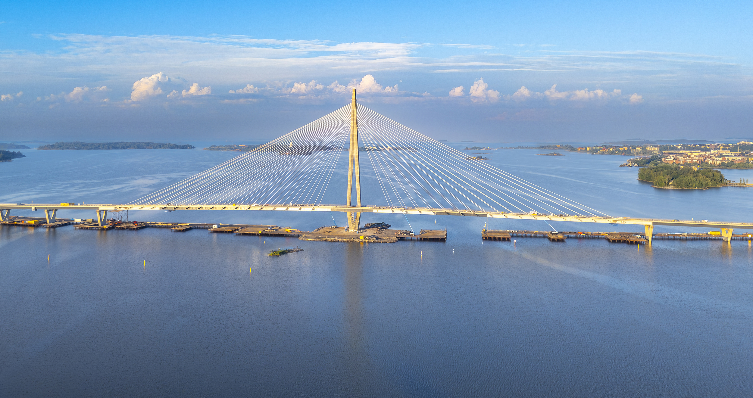 Aerial panorama of a white cable-stayed bridge over water