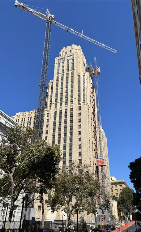 High‑rise building with construction crane against blue sky
