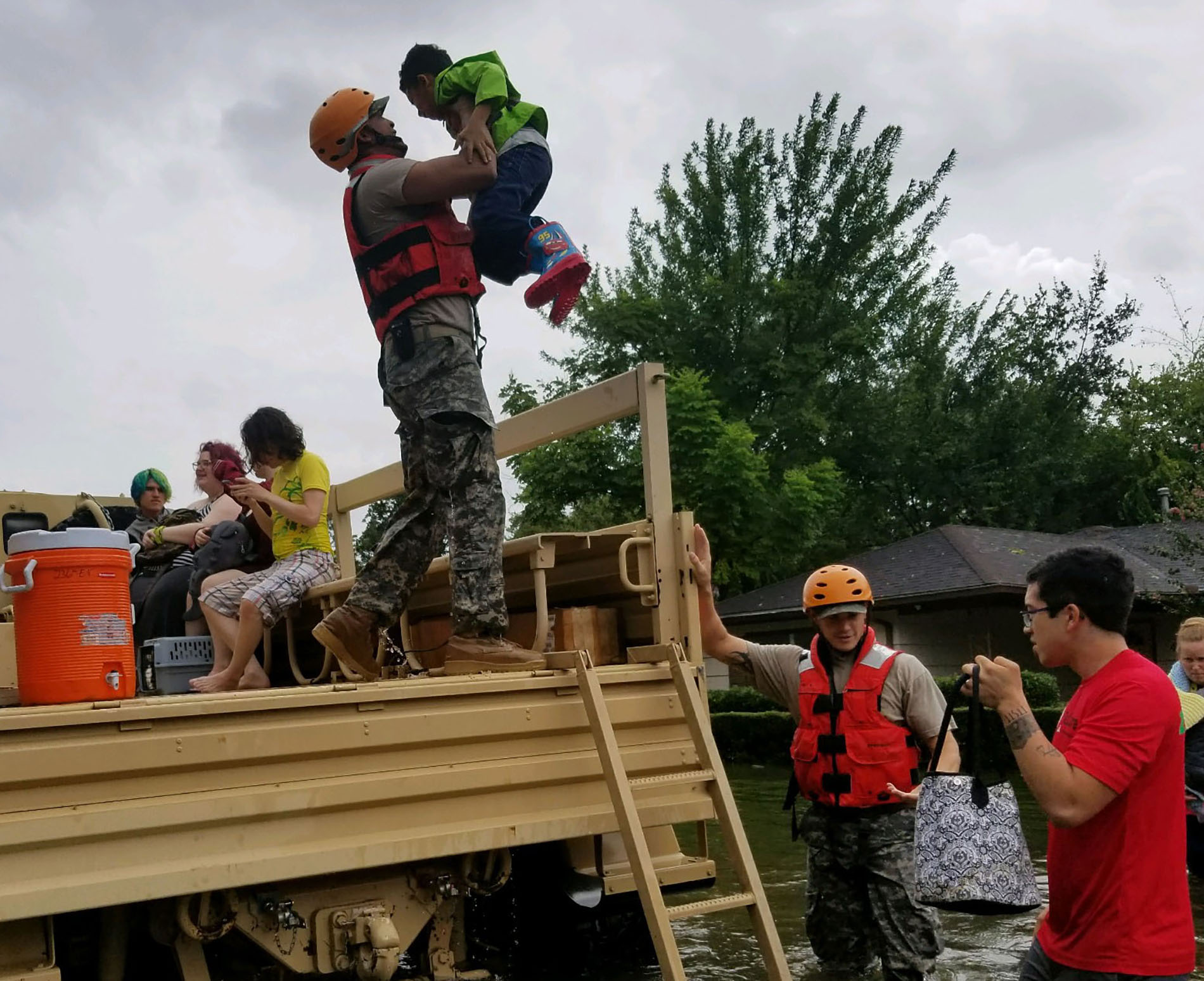 Rescuers load civilians onto truck through deep floodwaters during Hurricane Harvey
