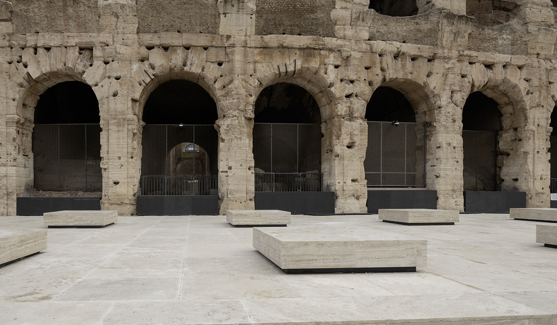 Restored Colosseum arches and new travertine paving with seating blocks