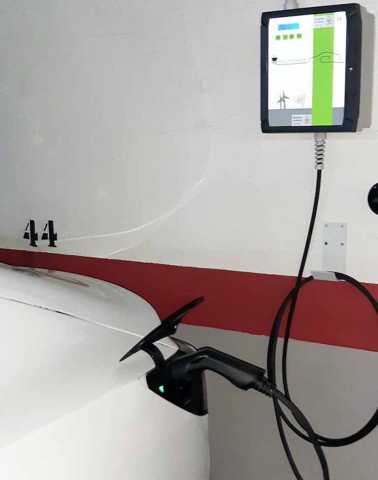 Electric vehicle charging in garage connected to wall-mounted charger