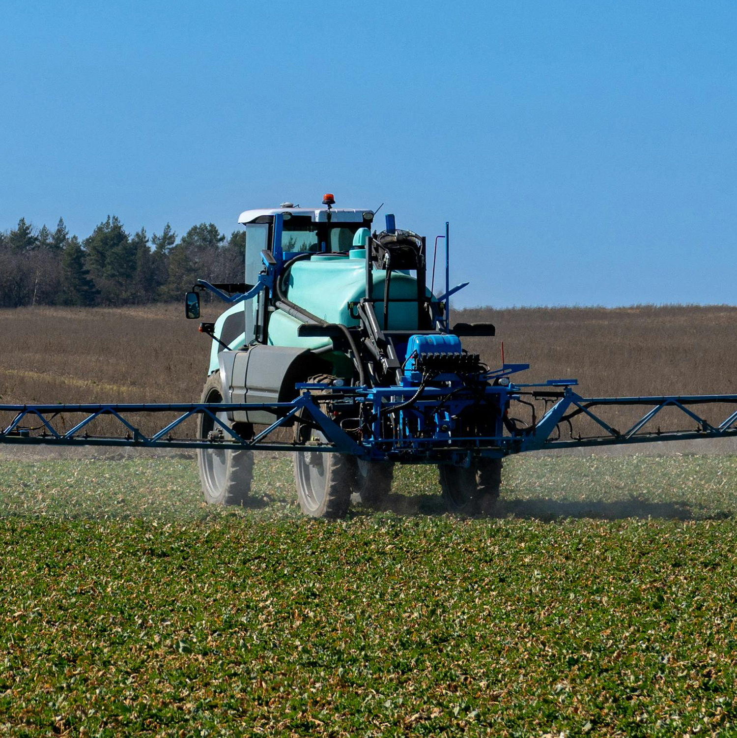 Agricultural sprayer applies fertilizer across a cultivated field