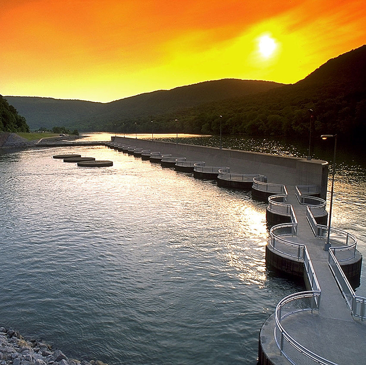 Hydropower intake structure and reservoir at sunset in mountain valley