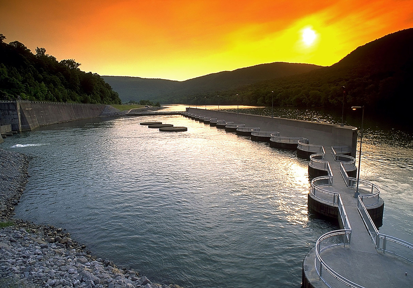 Hydropower intake structure and reservoir at sunset in mountain valley