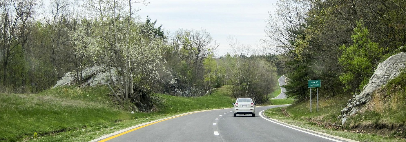 photo of a highway cut through a small hill